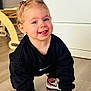 black_sweatshirt, blue_eyes, cabinet, child, crawling, cute, flooring, furniture, hair_ties, happy, indoor, nike, person, pigtails, pink_toothbrush, smiling, sneakers, toddler, wooden_floor, young