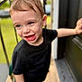 Jack is registered to the contest to win money with this photo: child, toddler, smiling, blue_eyes, black_shirt, short_hair, outdoor, door, hand, laughing, happy, portrait, person, young_child, casual_clothing, daylight, blurred_background, natural_light, skin, expression