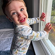 Jack is registered to the contest to win money with this photo: toddler, child, smile, pajamas, window, hands, light, indoor, bed, blanket, face, happy, cute, expression, young_child, animal_print, curtain, room, portrait, baby