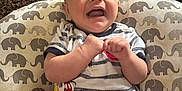 Ryder is registered to the contest to win money with this photo: baby, child, smiling, laughing, striped_shirt, mickey_mouse, red_pants, elephant_pattern, cushion, carpet, indoor, play_mat, happy, person, infant, cute, young, portrait, sitting, clothing