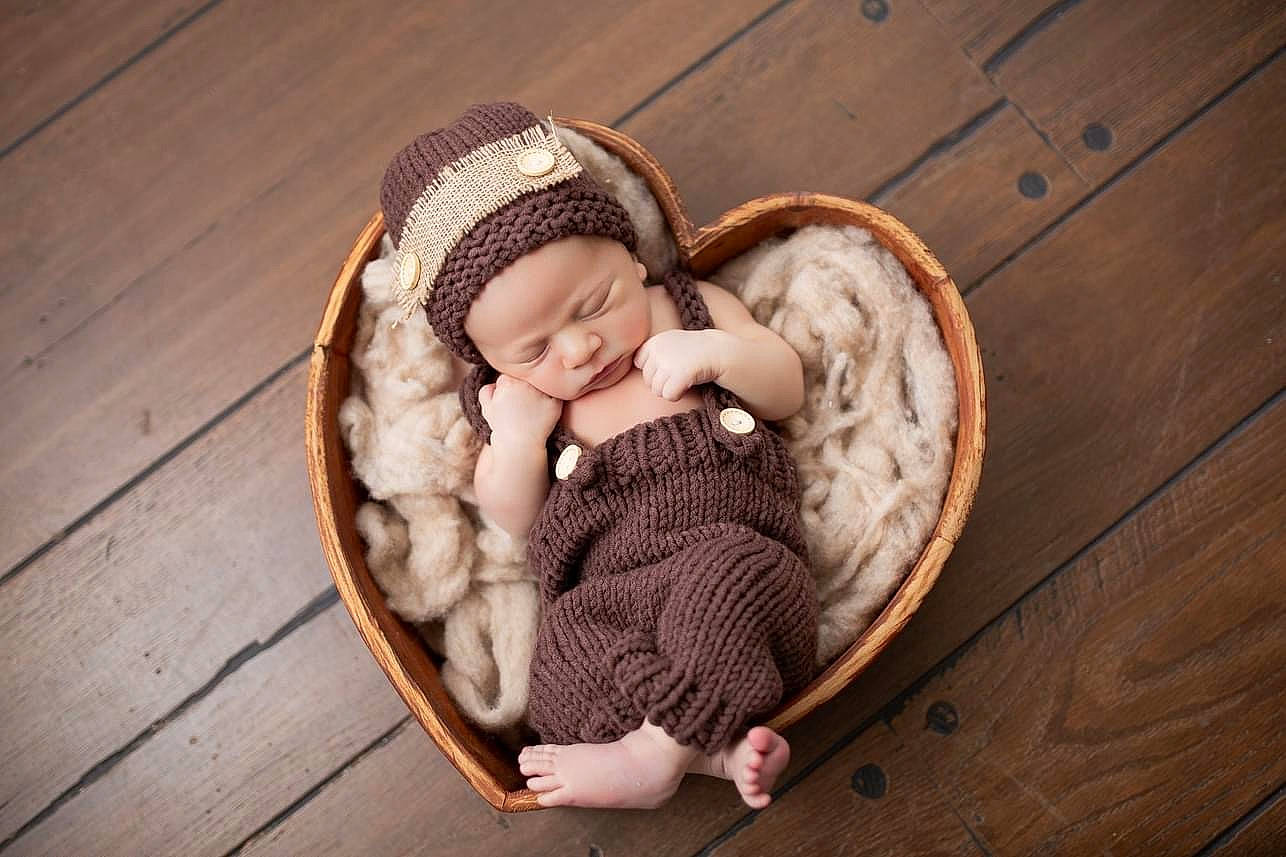 Koelton is registered to the contest to win money with this photo: baby, baby_products, baby_sleeping, baby_toddler_clothing, basket, child, comfort, crochet, flooring, grass, happy, hardwood, headwear, infant_bed, linens, person, sitting, toddler, wicker, wood