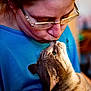 Bella participe au concours pour gagner de l'argent avec cette photo : person, cat, glasses, affection, close_up, indoor, pet, love, animal, human, face, whiskers, blue_clothing, intimate, bond, cute, domestic, feline, eyewear, tenderness