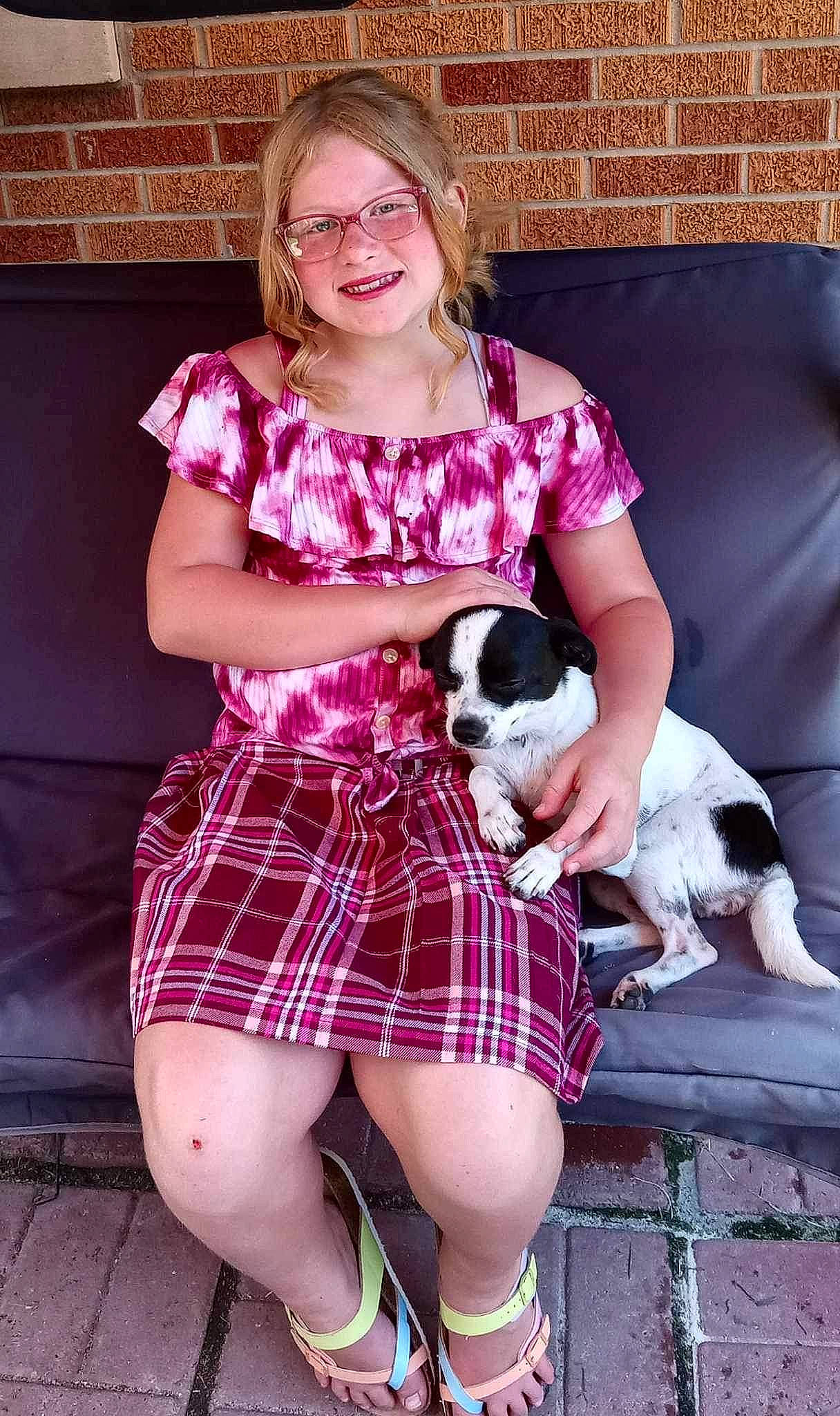 Cadence is registered to the contest to win money with this photo: carnivore, companion_dog, fawn, happy, human_leg, joy, knee, lap, leg, magenta, pattern, person, pink, plaid, purple, sleeve, smile, tartan, thigh, toy