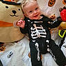 Hunter joined the competition — help win amazing prizes! baby, child, infant, smiling, happy, portrait, halloween, skeleton_costume, costume, witch_hat, teddy_bear, stuffed_animal, toy, blanket, indoor, lying_down, sitting, blond_hair, playful, closeup