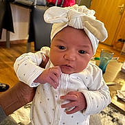 Inès a rejoint le concours — aidez-le/la à gagner de superbes lots ! baby, bow, child, clothing, cute, face, furniture, glass, hand, headband, holding, indoor, infant, newborn, onesie, person, seated, skin, table, wooden_floor