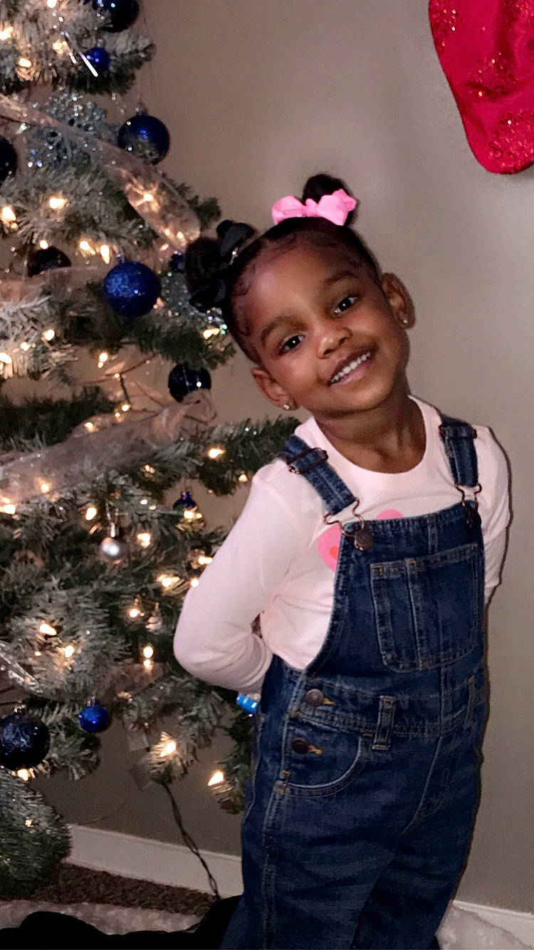 Aminah is registered to the contest to win money with this photo: baby_toddler_clothing, black, christmas_ornament, christmas_tree, facial_expression, fashion, fun, hairstyle, happy, head, holiday_ornament, human_body, joy, ornament, person, photograph, plant, purple, smile, standing