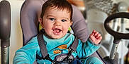 Hélio a rejoint le concours — aidez-le/la à gagner de superbes lots ! baby, infant, child, smiling, drooling, blue_clothing, baby_seat, highchair, harness, toy_giraffe, blanket, hand, face, eyes, happy, hair, indoor, bokeh_background, feeding_chair, playful