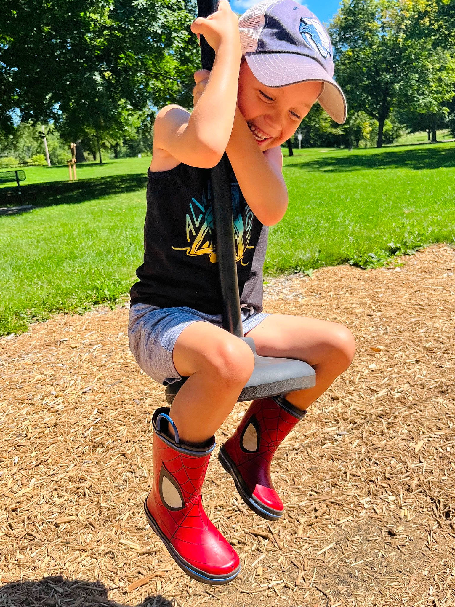 Miles is registered to the contest to win money with this photo: baseball_cap, cap, eyewear, footwear, grass, green, happy, hat, headwear, joy, knee, leg, person, plant, shoe, shorts, shoulder, sportswear, t_shirt, thigh