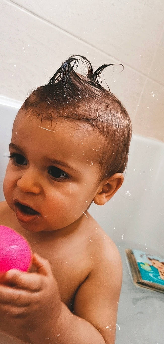 Marceau participe au concours pour gagner de l'argent avec cette photo : baby, baby_bathing, bathing, bathtub, black_hair, child, ear, eyebrow, face, forehead, hair, hairstyle, head, person, plumbing_fixture, skin, toddler, washing