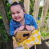 bow, bracelets, child, denim_jacket, fashion, floral_pattern, girl, greenery, happy, hello_kitty, necklace, outdoor, portrait, purse, silver_shoes, smile, sunlight, white_socks, wooden_deck, yellow_skirt