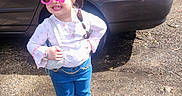Dayanis is registered to the contest to win money with this photo: child, girl, sunglasses, pink, jeans, white_shoes, car, parking_lot, sunlight, hair_bands, playful, posing, outdoor, chain_belt, long_sleeve_shirt, handbag, smiling, fashion, cute, confident