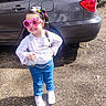 child, girl, sunglasses, pink, jeans, white_shoes, car, parking_lot, sunlight, hair_bands, playful, posing, outdoor, chain_belt, long_sleeve_shirt, handbag, smiling, fashion, cute, confident