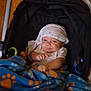 baby, blanket, blue, orange, paws, stroller, child, infant, smile, cloth, headwear, indoor, floor, wooden_floor, seat, toy, playful, cute, person, cozy