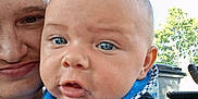 Johnny is registered to the contest to win money with this photo: adult, baby, bib, black_shirt, blue_eyes, child, closeup, clothing, daylight, expression, face, head, outdoor, person, portrait, selfie, skin, sunlight, trash_bin, tree