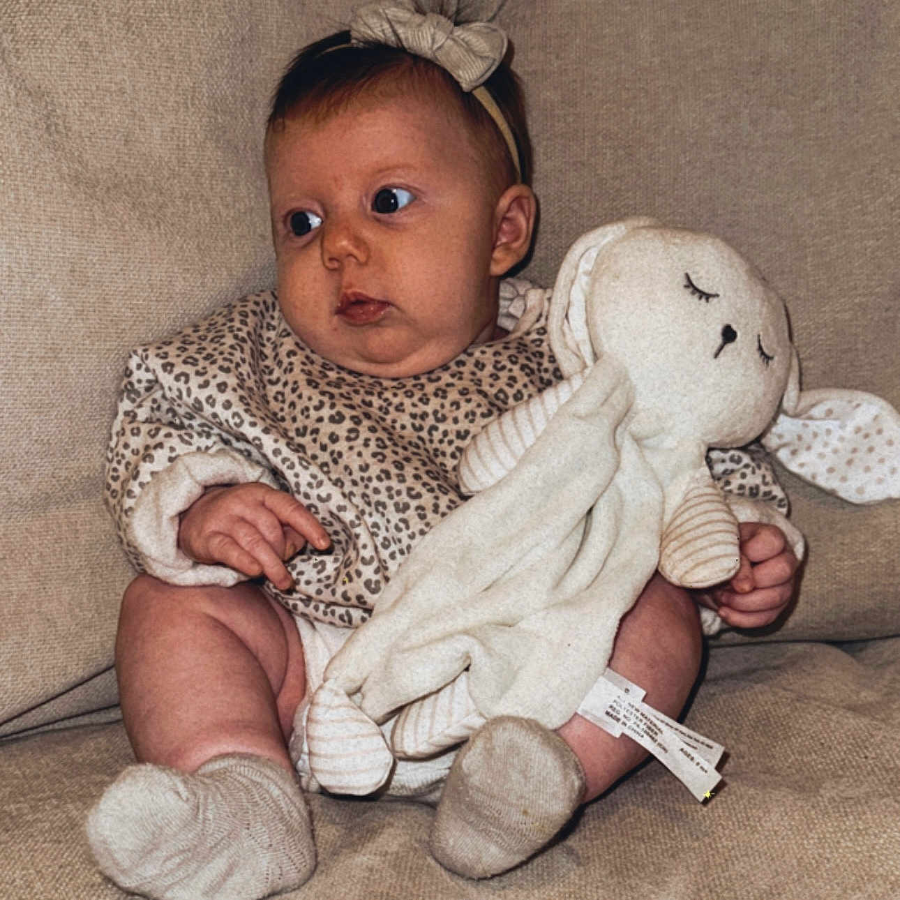 Poppy is registered to the contest to win money with this photo: applique, armchair, baby, barefoot, bed, blanket, bodypart, bonnet, chair, clothing, couch, cushion, doll, face, finger, furniture, glove, hand, happy, hat