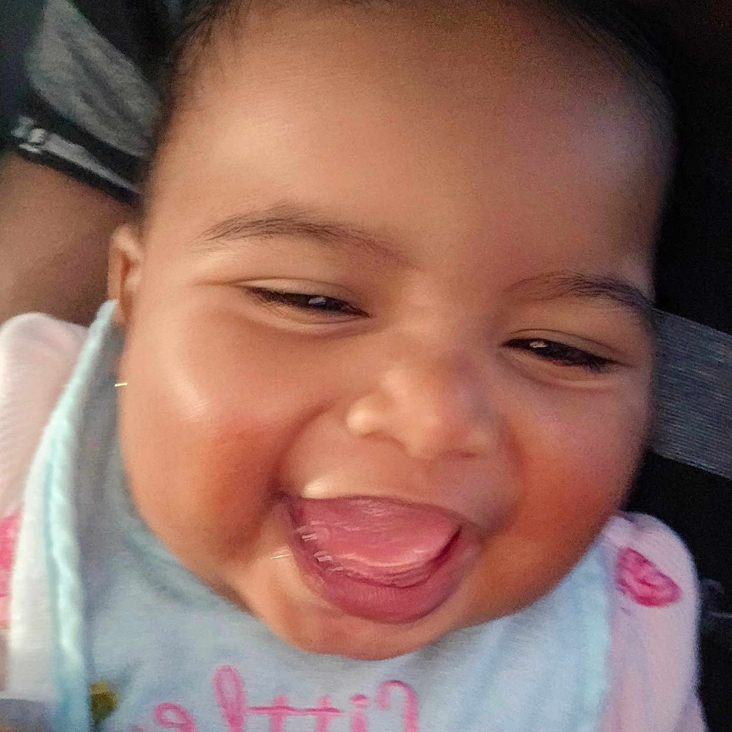 Ahnya-Ann is registered to the contest to win money with this photo: baby, bib, cheeks, child, close_up, clothing, cute, expression, eyes, face, happy, indoors, infant, joy, mouth, person, skin, smiling, tongue_out, young