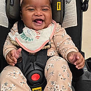Ahnya-Ann is registered to the contest to win money with this photo: baby, child, smiling, car_seat, headband, floral_clothing, socks, infant, happy, cute, indoors, seatbelt, black_car_seat, pink, clothing, portrait, baby_accessory, baby_bib, baby_toy, baby_safety