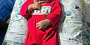 Ahnya-Ann joined the competition — help win amazing prizes! baby, infant, red_clothing, onesie, headband, bow, smiling, happy, lying_down, cushion, floral_pattern, indoor, child, cute, festive, christmas, polka_dots, portrait, skin, hand
