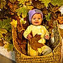 Aurora is registered to the contest to win money with this photo: baby, child, smile, face, purple_beanie, yellow_pajamas, basket, autumn_leaves, fall, leaf, indoors, cozy, cute, person, infant, warm, seasonal, nature, playful, happy