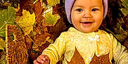 Aurora is registered to the contest to win money with this photo: baby, child, autumn, fall_leaves, basket, smiling, purple_hat, yellow_outfit, leaf, outdoor, seasonal, cute, portrait, nature, cozy, happy, infant, playful, warm_colors, baby_face