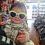 baby, child, sunglasses, indoor, store, stroller, clothing, hand, person, holding, toy, blanket, floor, light, window, face, cute, pattern, accessory, shopping