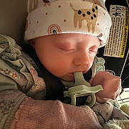 Luna joined the competition — help win amazing prizes! baby, infant, sleeping, pacifier, hat, mittens, car_seat, car_seat_label, blanket, close_up, newborn, cozy, seatbelt, infant_clothing, headwear, peaceful, cute, rosy_cheeks, plush_toy, soft_lighting