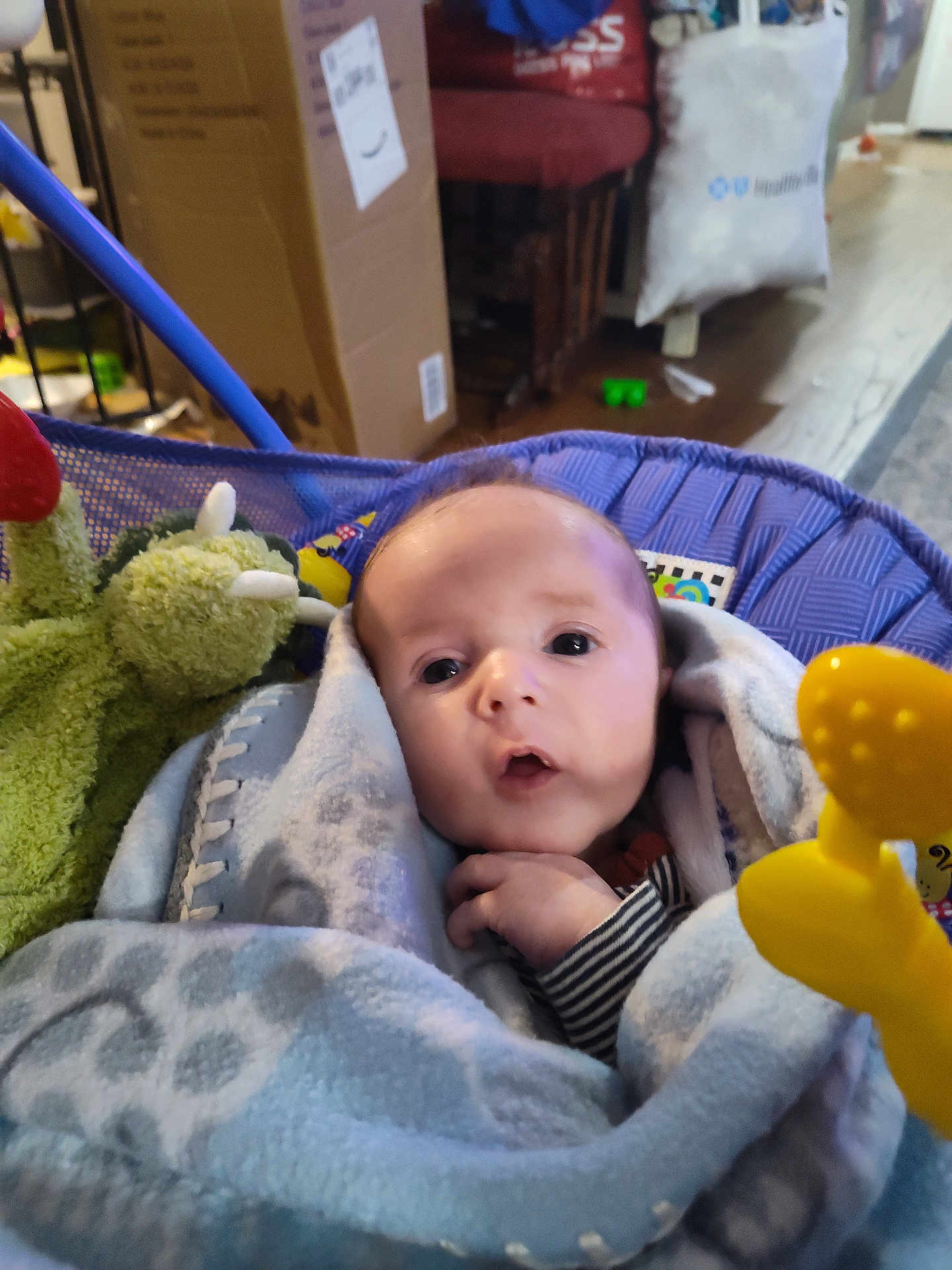 Theodore joined the competition — help win amazing prizes! baby, blanket, toy, face, infant, indoor, child, person, blue, soft, cozy, curious, wrapped, seated, furniture, box, floor, hand, expression, home