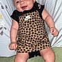 Londyn joined the competition — help win amazing prizes! baby, infant, smiling, headband, flower, nike, dress, leopard_print, socks, shoes, pillow, blanket, indoors, cute, person, child, happy, skin, legs, furniture