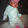 Londyn is registered to the contest to win money with this photo: baby, infant, onesie, pink_flower, headband, flamingo_pattern, pink_booties, pacifier, cushion, bedspread, smiling, cheerful, clothing, indoor, child, cute, resting, portrait, person, baby_girl