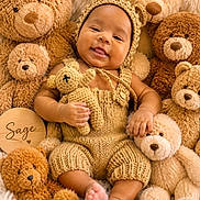 Sage is registered to the contest to win money with this photo: baby, teddy_bear, knitted_clothing, smiling, cute, plush_toys, child, soft_texture, cozy, portrait, infant, cuddly, cute_outfit, handmade, warm_colors, cute_baby, toy, happy, cute_face, baby_boy