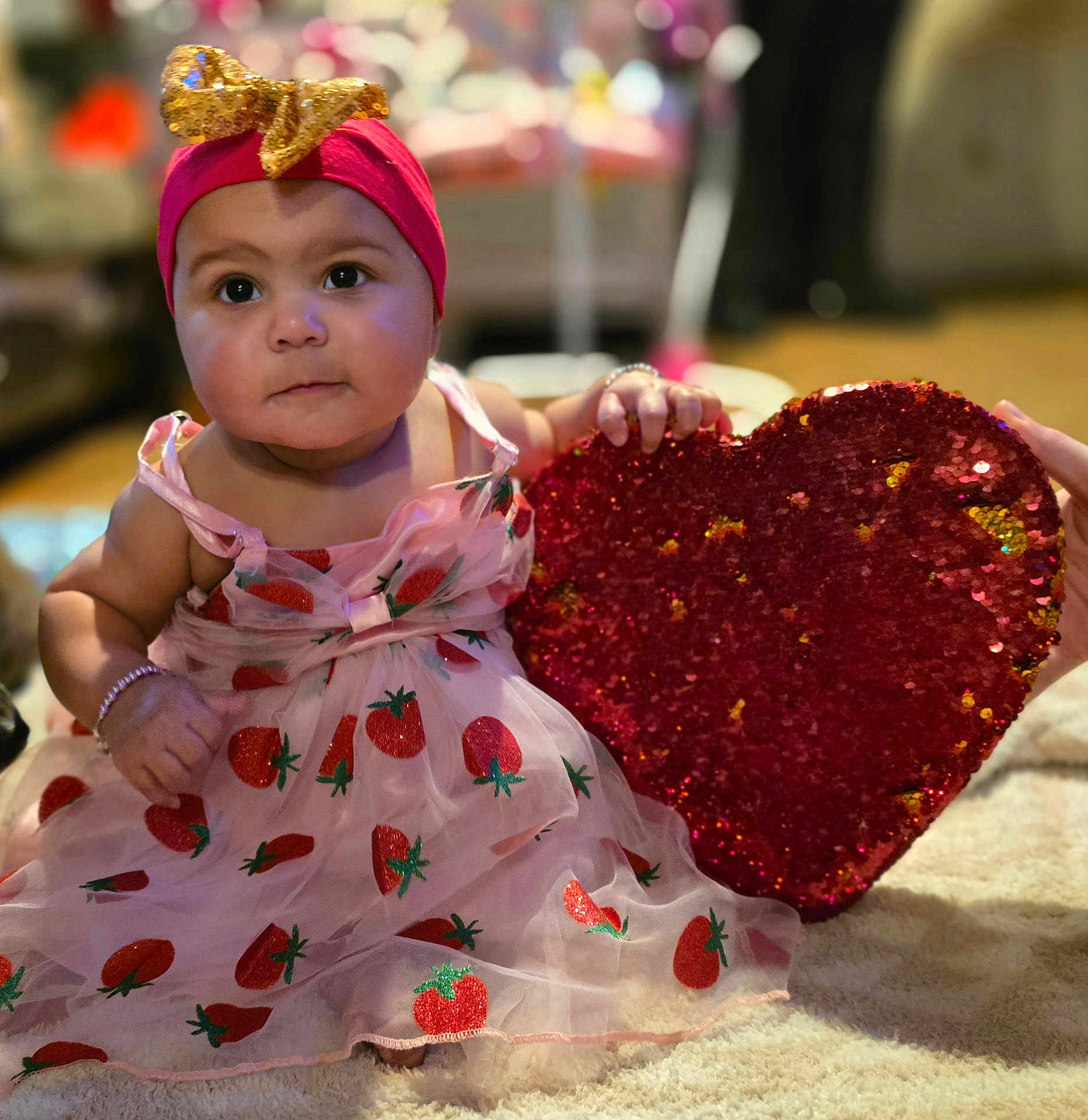 Azavia is registered to the contest to win money with this photo: baby, big_eyes, bracelet, carpet, child, closeup, cute, dress, gold_bow, hands, headband, indoors, infant, portrait, red_heart, rosy_cheeks, sequin_heart, sitting, sparkle, strawberry_print
