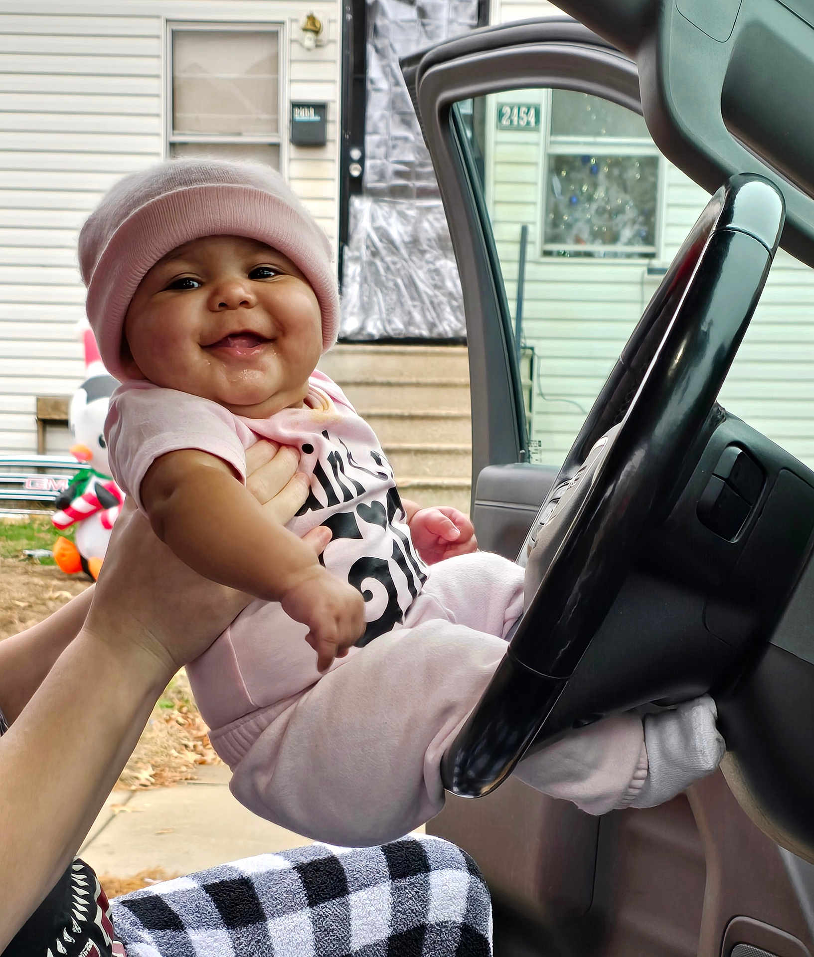 Azavia joined the competition — help win amazing prizes! baby, car_interior, child, door, face, hand, happy, hat, house, infant, inflatable_decoration, outdoor, person, pink_clothing, plaid_pants, portrait, seat, smiling, steering_wheel, window