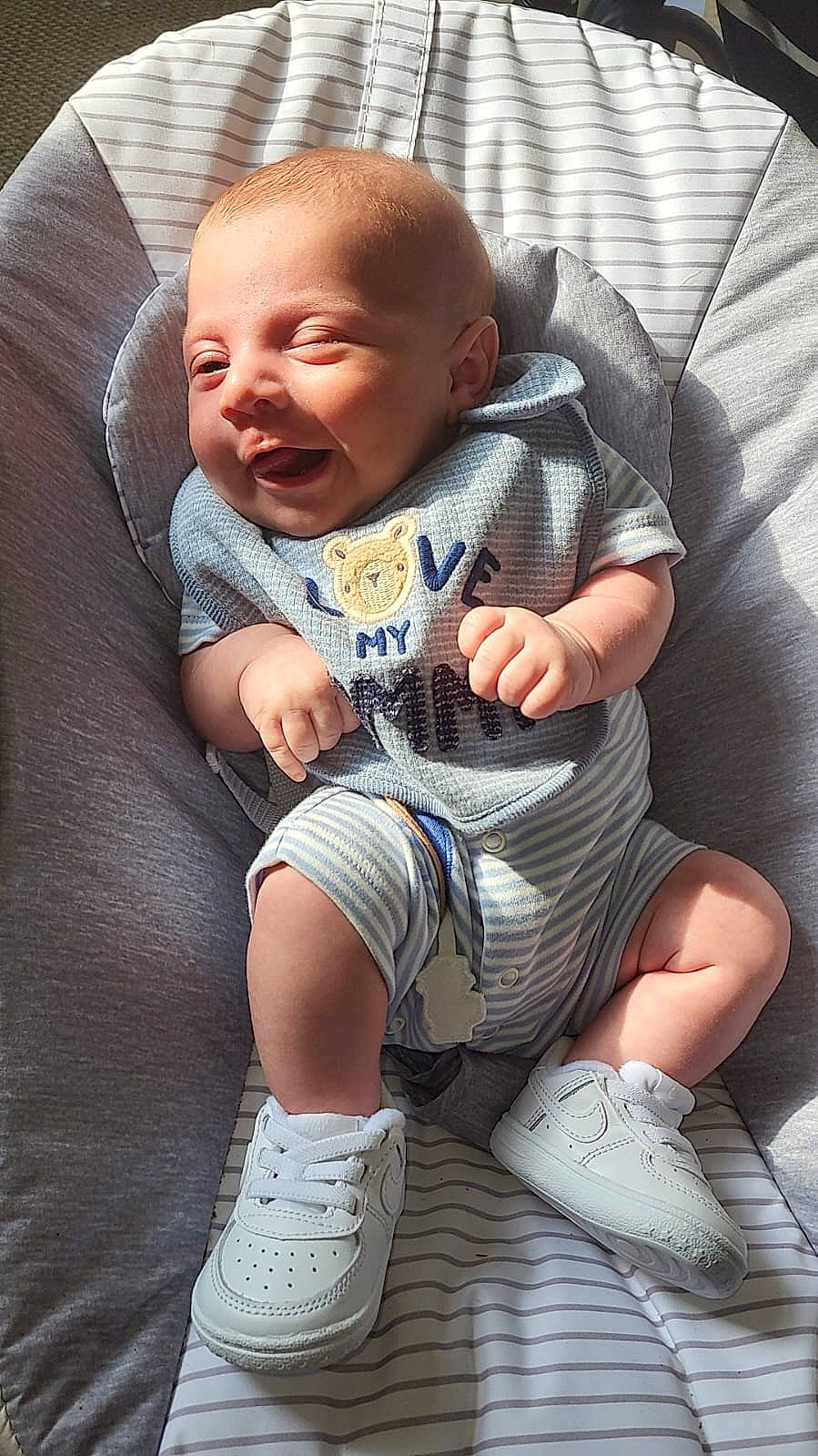 Harrison is registered to the contest to win money with this photo: arm, baby, baby_toddler_clothing, comfort, eye, face, finger, gesture, grass, grey, hand, head, human, human_body, leg, person, skin, sleeve, textile, thigh