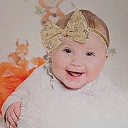 Evelyn joined the competition — help win amazing prizes! baby, smiling, headband, bow, blanket, orange, cute, animal_illustration, child, happy, portrait, infant, soft_texture, clothing, face, cute_expression, indoors, baby_girl, closeup, playful