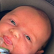 Ryan is registered to the contest to win money with this photo: baby, infant, pacifier, blanket, animal_print, car_seat, face, closeup, child, cute, resting, soft_texture, young, portrait, baby_clothing, head, eyes, skin, comfort, indoor