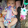 October is registered to the contest to win money with this photo: baby, bottle, stroller, blue_eyes, blanket, unicorn_toy, footwear, outdoor, child, infant, colorful_clothing, milk, feeding, cute, soft_toy, legs, toes, summer, usa_theme, relaxing