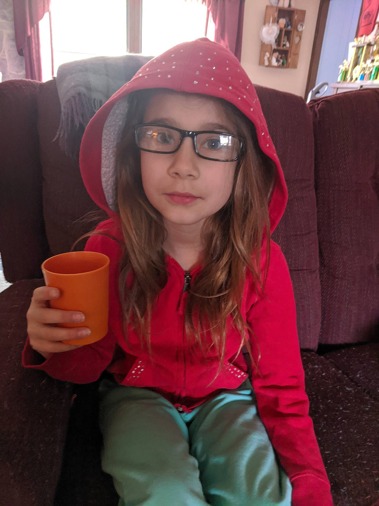 Katrina is registered to the contest to win money with this photo: brown_hair, child, cool, eyewear, face, fashion_accessory, glasses, hat, head, headgear, headwear, lip, long_hair, outerwear, person, photography, pink, sitting, smile, sunglasses