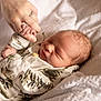 Dawson is registered to the contest to win money with this photo: baby, newborn, sleeping, hand, adult, blanket, clothing, pattern, cozy, soft, skin, face, infant, peaceful, rest, cute, tender, small, person, portrait