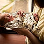 newborn, baby, infant, person, holding, arms, window, light, indoors, clothing, sleeping, closeup, portrait, human, toddler, soft_light, cozy, adult, hands, cute