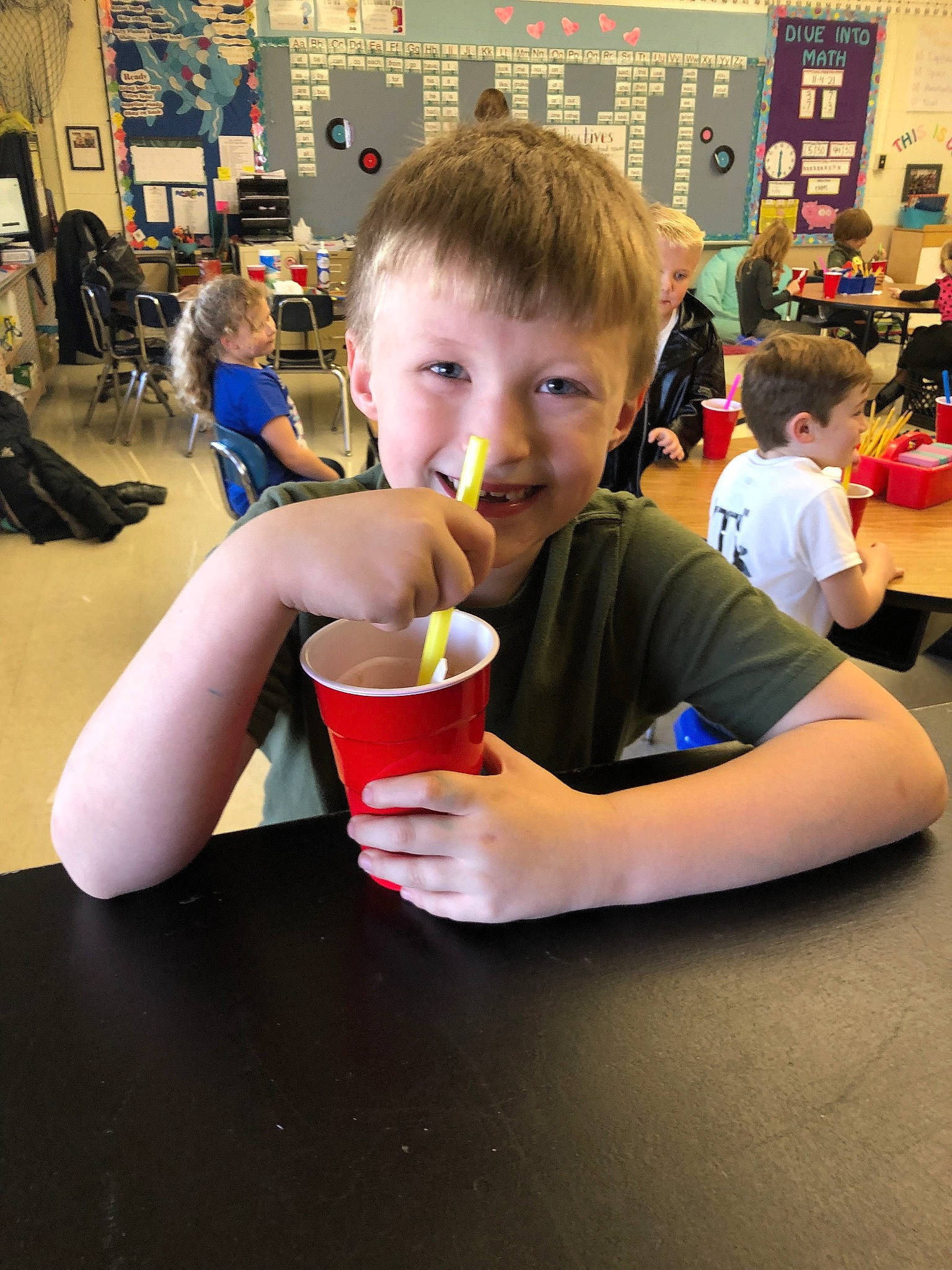 Hunter is registered to the contest to win money with this photo: chair, child, cup, drink, drinking, drinkware, event, flooring, fun, hair, happy, head, joy, person, play, recreation, smile, t_shirt, table, tableware