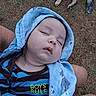 Landon is registered to the contest to win money with this photo: baby, sleeping, blanket, blue, striped_clothing, boy, outdoor, grass, dog, pet, resting, peaceful, person, child, cute, wrapped, hand, legs, nature, relaxation