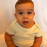 Reuben joined the competition — help win amazing prizes! baby, background, casual, child, closeup, curious, cute, expression, eyelashes, face, hands, head, indoors, infant, person, portrait, sitting, skin, white_shirt, young