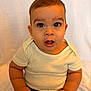 baby, background, casual, child, closeup, curious, cute, expression, eyelashes, face, hands, head, indoors, infant, person, portrait, sitting, skin, white_shirt, young