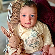 Santino participe au concours pour gagner de l'argent avec cette photo : baby, child, blue_eyes, stuffed_animal, bunny, soft_toy, cream_shirt, animal_illustration, blanket, maroon_throw, indoor, portrait, cute, cozy, curious, hand, face, sitting, young, infant