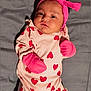 baby, infant, pink_outfit, hearts, mittens, headband, bow, lying_down, blanket, cute, adorable, portrait, child, soft_texture, clothing, newborn, indoor, expression, face, person