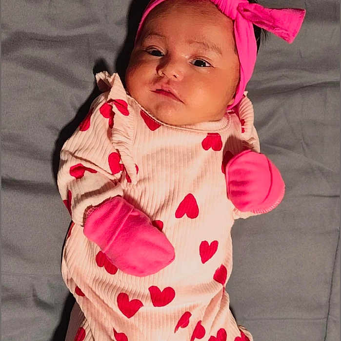 Emma Falla joined the competition — help win amazing prizes! adorable, baby, blanket, bow, child, clothing, cute, expression, face, headband, hearts, indoor, infant, lying_down, mittens, newborn, person, pink_outfit, portrait, soft_texture