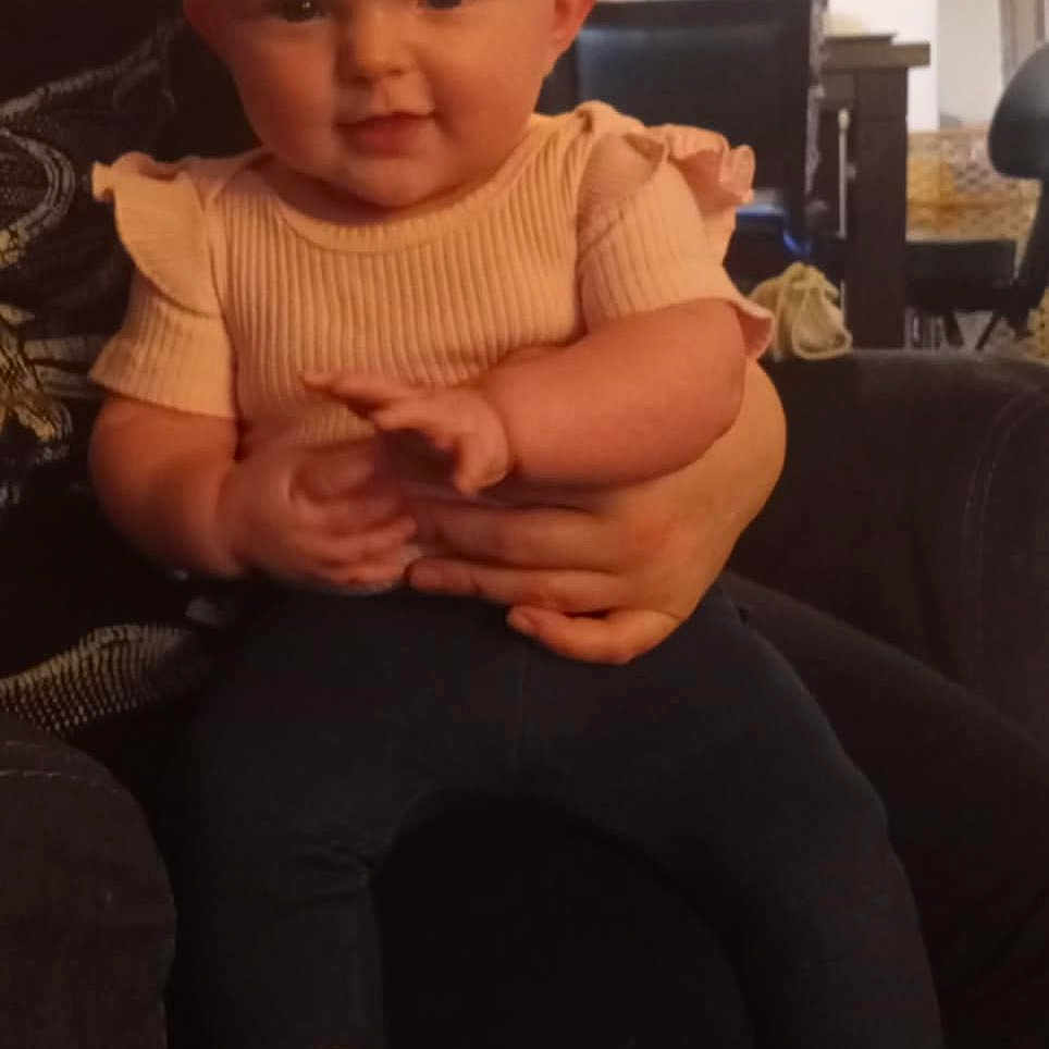 Liliana joined the competition — help win amazing prizes! architecture, baby, building, cap, clothing, couch, cushion, face, furniture, hat, head, homedecor, indoors, livingroom, pants, person, photography, portrait, room, sitting