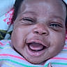 Eliyanah joined the competition — help win amazing prizes! baby, infant, child, smiling, laughing, close_up, portrait, face, eyes, mouth, hand, thumbs_up, striped_clothing, rainbow_colors, floral_bedding, lying_down, indoor, happy, cute, photograph