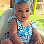 baby, child, blue_bow, headband, high_chair, cute, indoors, infant, person, portrait, sitting, young, clothing, face, hand, skin, expression, looking, summer, daylight