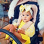 Angel is registered to the contest to win money with this photo: baby, child, stroller, yellow_dress, bow, headband, lollipop, foot, indoor, cafe, people, seated, window, reflection, table, chair, floor, blanket, cute, portrait